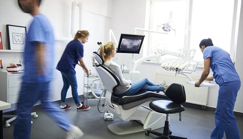 Blurred view of dentists and woman in dentist's Clinic